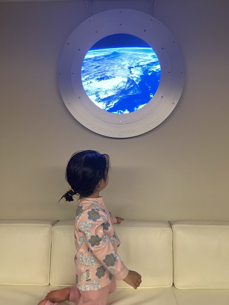 GENSOを見上げる子ども。舷窓の向こうに地球